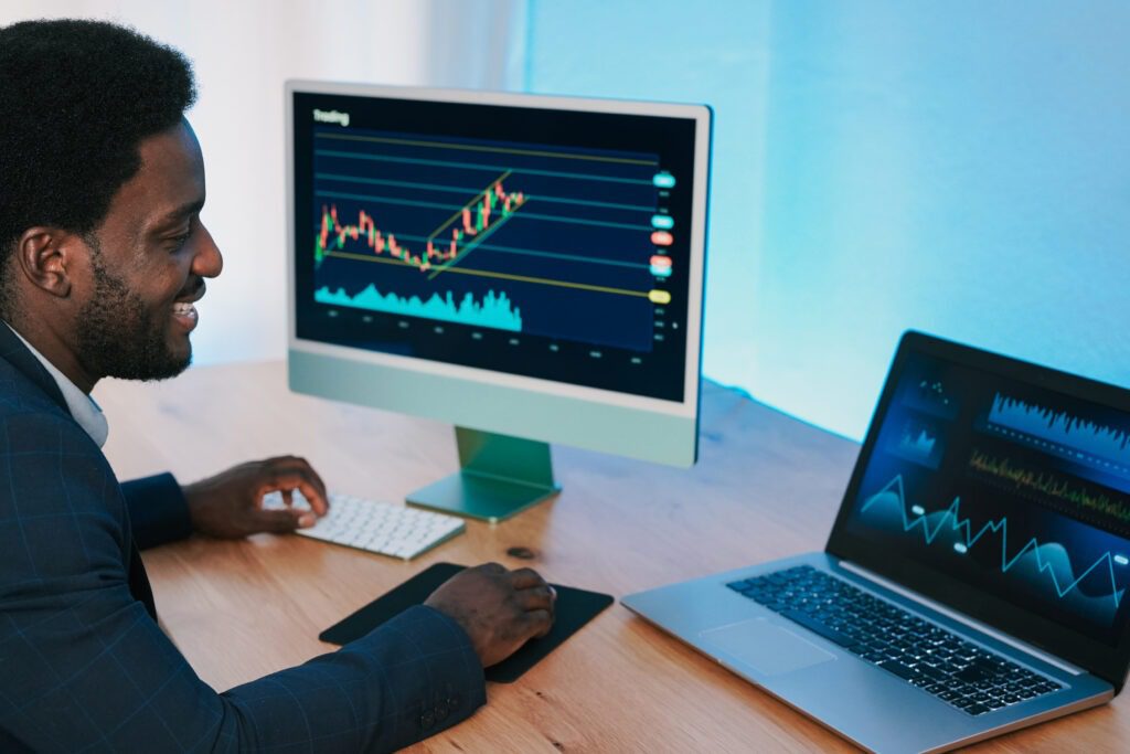 African trader man working inside hedge fund office doing stock